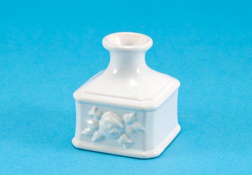 small white retro ceramic vase dish decoration with ornaments on blue background.