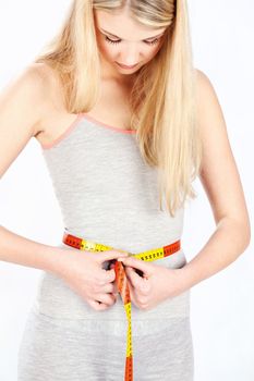 Young blonde woman measure her  waist