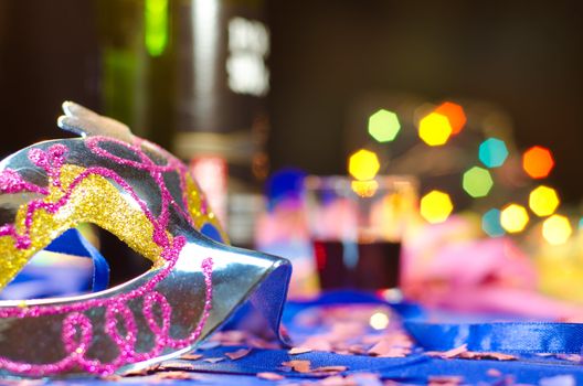 Carnival mask with a party background including as second subject's a drink and a bottle