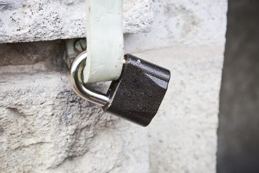 Locked padlock  on stone wall.