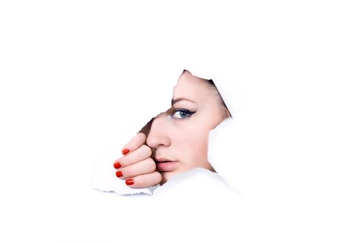 Young girl looking through hole in white paper