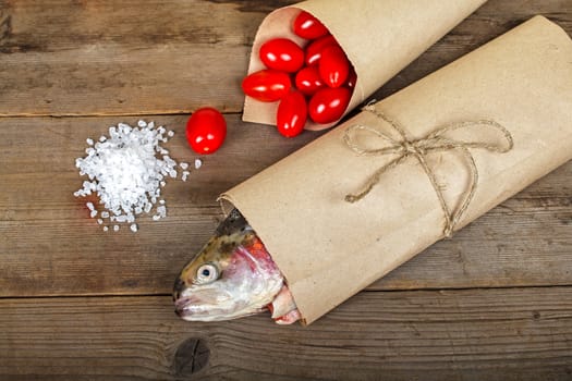 Fresh salmon in the paper-bag with tomato and salt