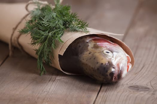 Fresh salmon in the paper-bag with a piece of greenery
