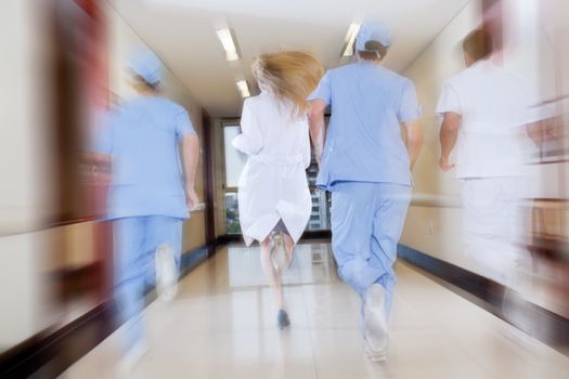 Doctor and nurse running in passageway of hospital