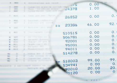 Closeup view of magnifying glass looking at financial report