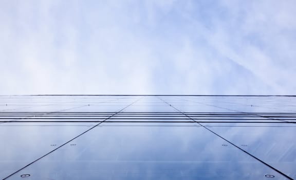 facade of glass and reflection of sky and clouds