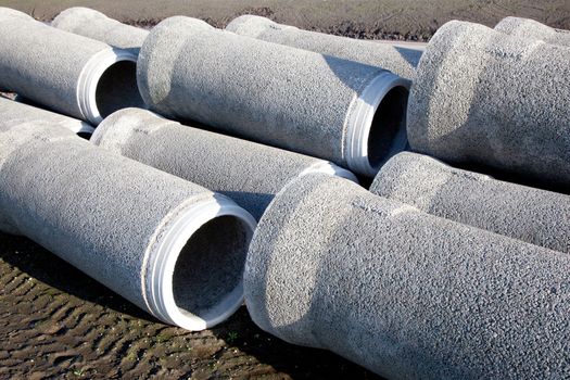 grey concrete pipes waiting to be put under the ground