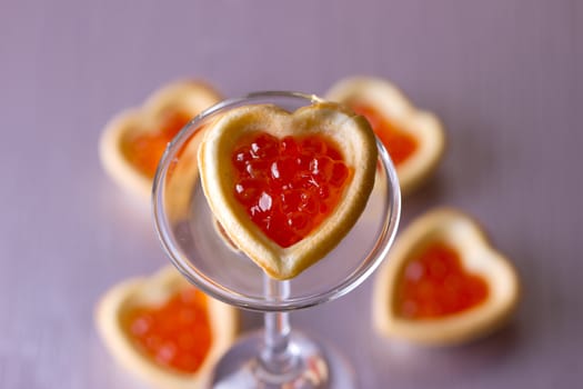 Tartlets with heart-shaped eggs on a glass base