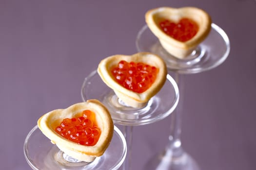 Tartlets with heart-shaped eggs on a glass base