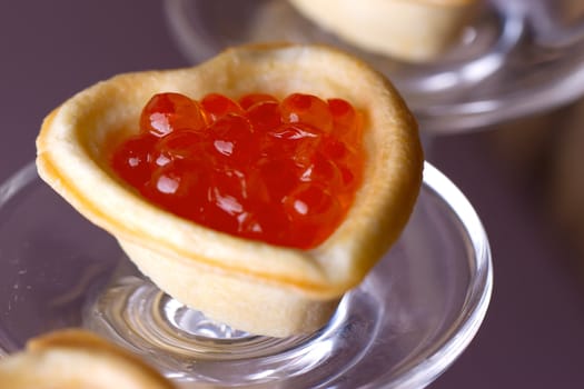 Tartlets with heart-shaped eggs on a glass base