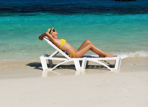 Girl on a tropical beach with hat