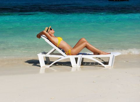 Girl on a tropical beach with hat