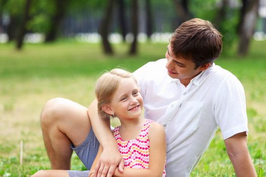 A dad and his daughter are together in the park