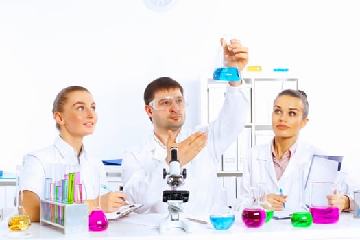 Team of scientists working with liquids in laboratory