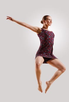 Girl dancing in a color dress with a gray background. isolate