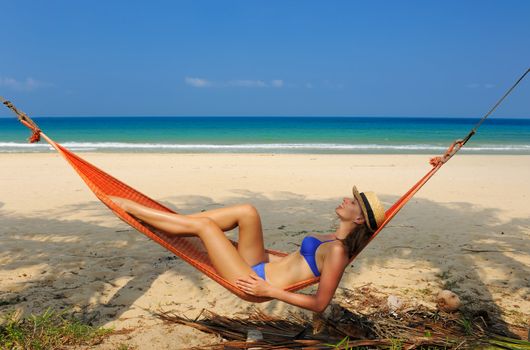 Woman in hammock on tropical beach at Tioman island, Malaysia