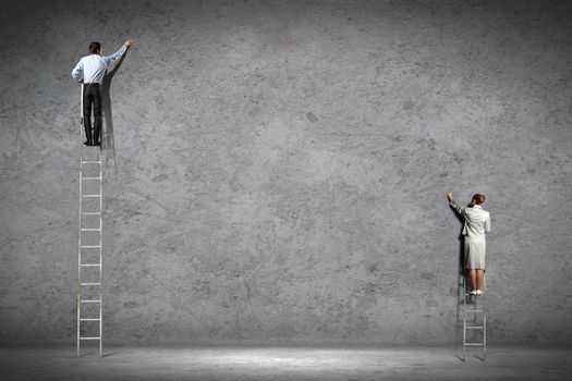 businesspeople standing on ladder drawing diagrams and graphs on wall