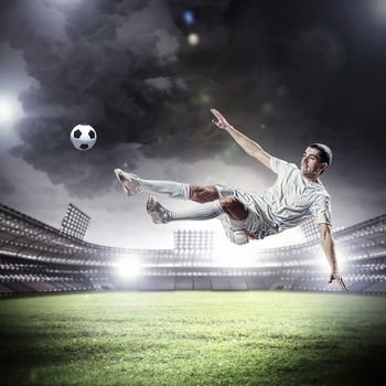 football player in white shirt striking the ball at the stadium