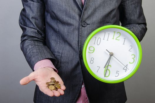An image of young businessmen holding money and watch in his hands