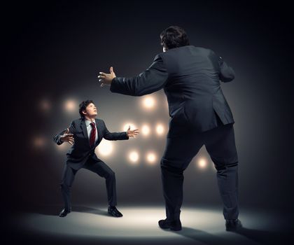 Image of businesspeople arguing and acting as sumo fighters