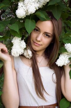 Portrait of a beautiful girl with white lilacs on his head