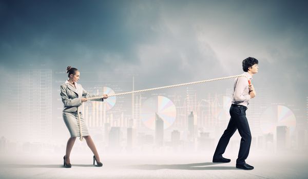 Image of three businesspeople with rope against diagram background