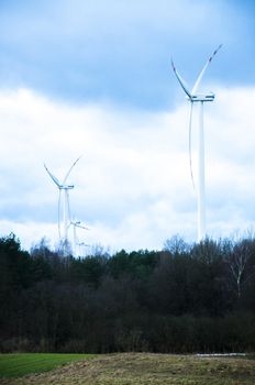 An image of windturbine generator over cloudy sky