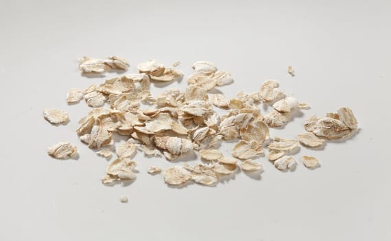Handful of oat flakes on the gray background