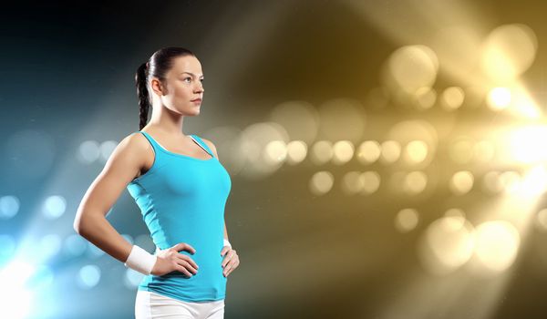 Image of sportswoman exercising against lights background