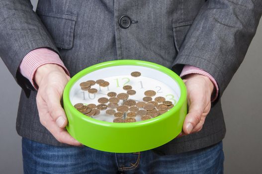 An image of young businessmen holding money and watch in his hands