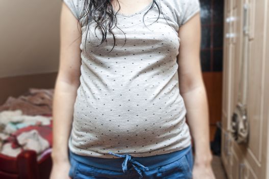 An image of pregnant teenager without head