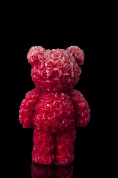 An image of red candle bear with roses surface