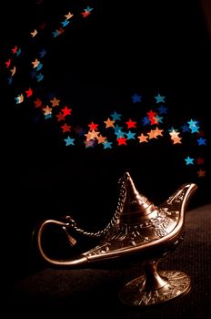 the lamp of Aladdin with stars light on a black background