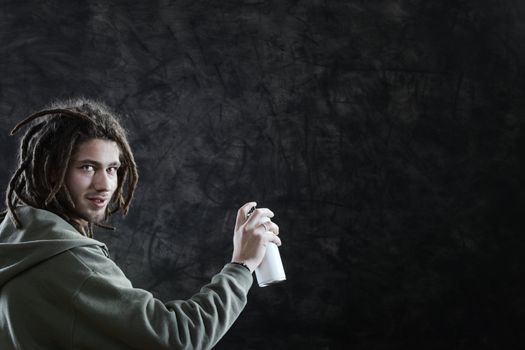 Young man about to draw a graffiti on a wall with copyspace