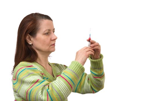 woman looks at a syringe - isolated on white background