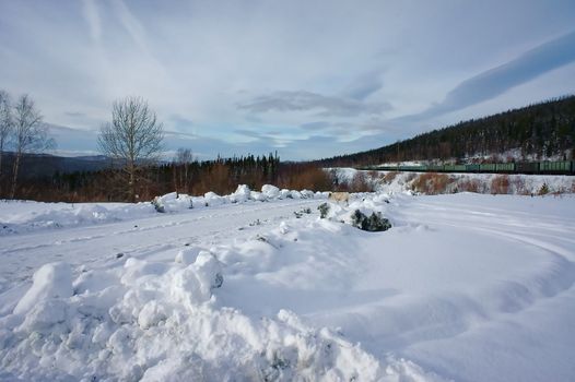 Winter landscape with train and road.