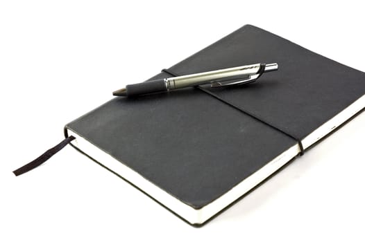 black notebook with pen on white background