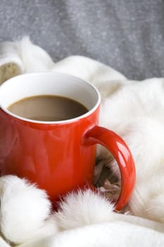 red cup of coffee put on wool scarf