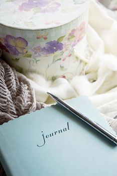 woman's journal and flower box in window light