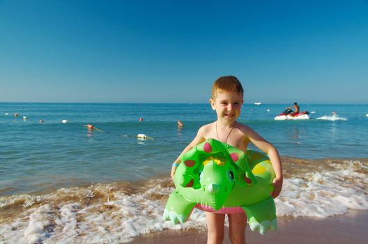 Little boy in the waves on the sea beach