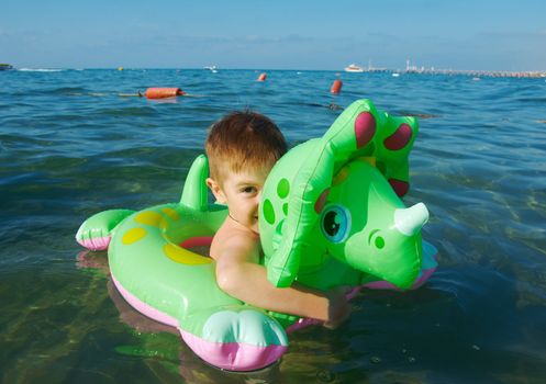 Little boy in the waves on the sea beach