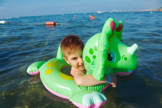 Little boy in the waves on the sea beach