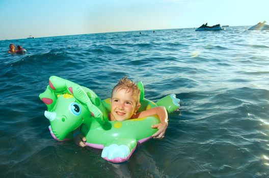 Little boy in the waves on the sea beach