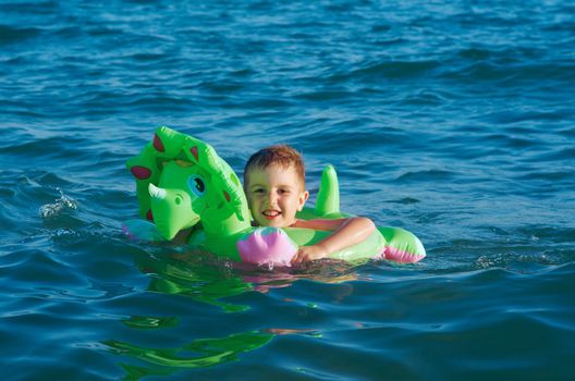 Little boy in the waves on the sea beach