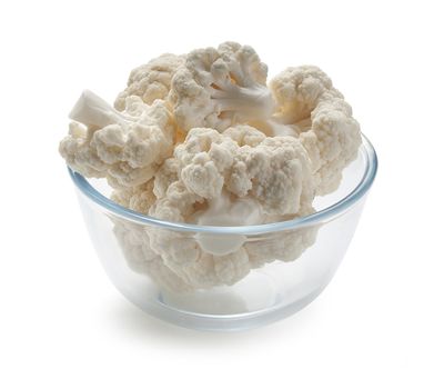 Some branches of cauliflower in the glass bown on the white