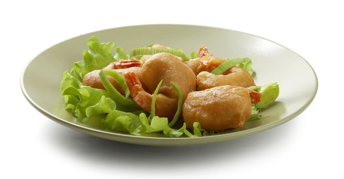 Shrimp tempura with lettuce, leek and sesame on the green plate