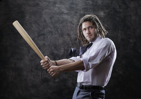 Young businessman swinging baseball bat