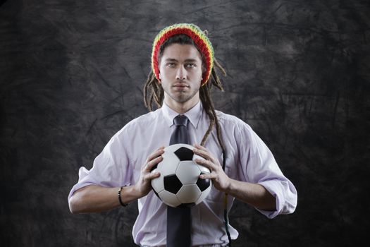 Portrait of a bizarre businessman with a soccer ball