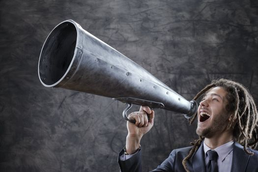 Young businessman yelling trough a vintage megaphone