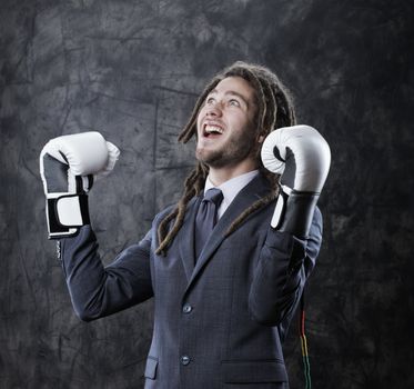Young businessman shouting his victory, he wearing boxes gloves